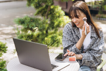 Woman creating online beauty content with makeup outdoors