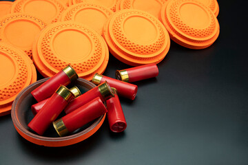 Clay disc flying targets and shotgun bullets on black background ,Clay Pigeon target