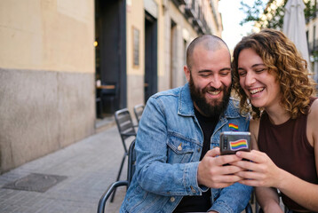 Happy diverse couple smiling watching smartphone together