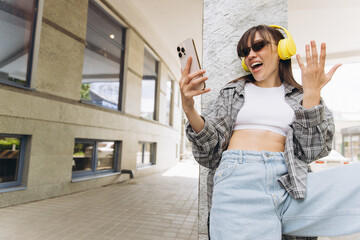 Young woman enjoying music and video chat street