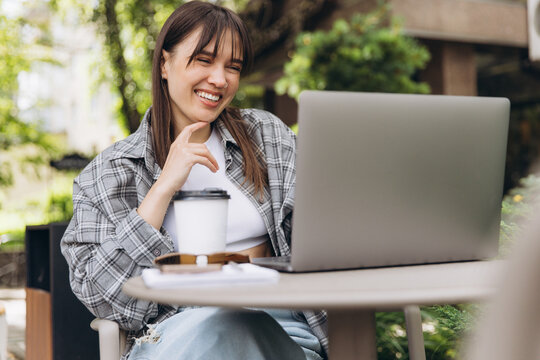 Young woman laughing during video call outdoors