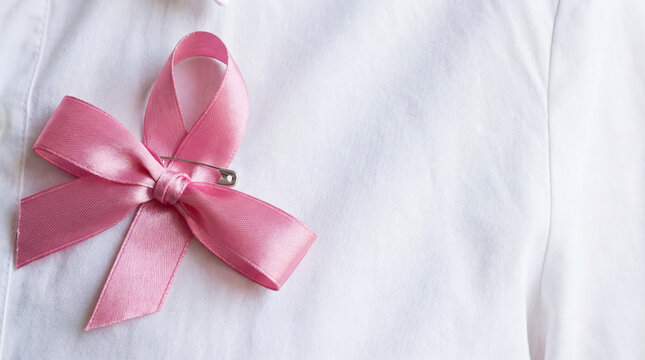Pink Breast Cancer Awareness Ribbon Pinned on White Shirt