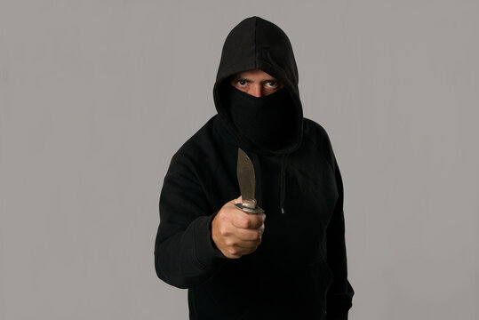 Hombre encapuchado amenazante con un cuchillo