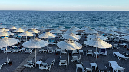 Beach scene with white umbrellas and lounge chairs by the sea