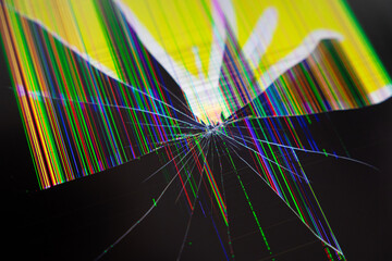 Cracked electronic screen with radiating shatter lines and vibrant distorted multicolored pixels, symbolizing digital technology breakdown, damage, and urgent repair