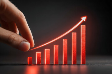 Hand guiding upward glowing red bar chart growth arrow symbolizing business success and increasing financial performance against dark background