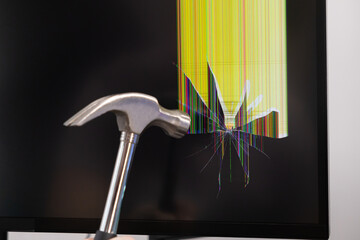 A powerful metal hammer striking a fragile black computer monitor screen, causing dramatic shattered glass and vibrant broken pixel lines, reflecting technological frustration or hardware damage