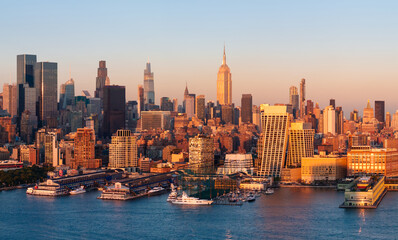Fototapeta premium Aerial panoramic view of the Manhattan skyline at sunset, with Midtown skyscrapers, Hudson River waterfront and Chelsea piers. New York City, USA