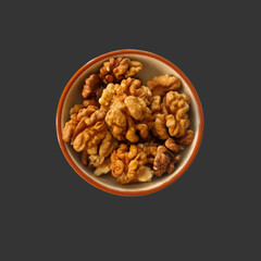 A small bowl with a handful of shelled walnuts on a black background, close-up, healthy snack.
