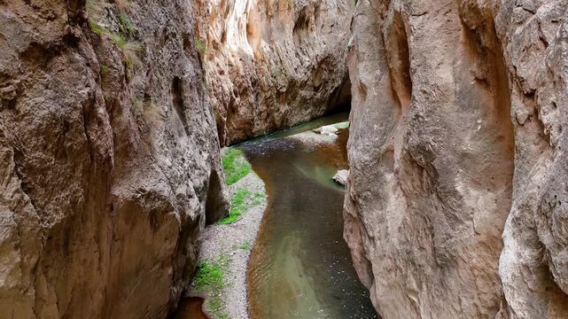 Breathtaking high angle view of a serene river flowing through a deep and narrow gorge. Impressive geological formations and sheer cliffs