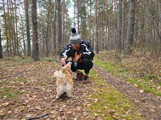 Man Playing with Corgi Dog in Autumn Forest