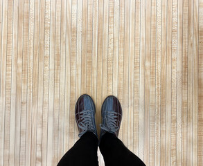 A girl stands on a wooden floor in bowling shoes. Leisure concept.