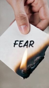 Burning paper with word fear written on it, concept of courage, emotional release, overcoming anxiety, inner strength and mental resilience symbolism