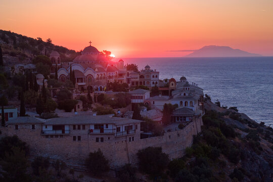 Aerial view of Greek Orthodox monastery of Archangel Michael on Thassos during a vivid sunrise. Ideal for: travel blogs, Greece tourism, architecture themes, spirituality visuals. 