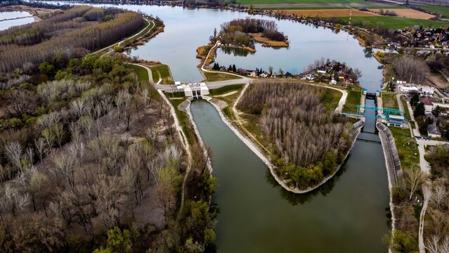 Aerial view of water channel and lock system near lake and forest

