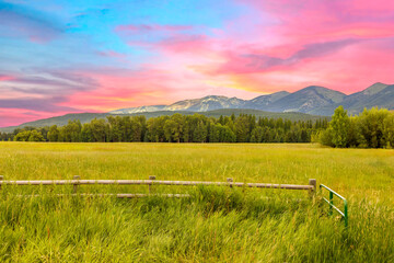 a farmer's field with mountains and sunset in the background in northwest Montana