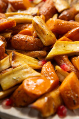 Close up of oven baked carrots and parsnips wooden surface