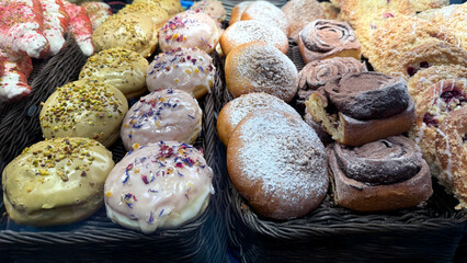 Assorted pastries and donuts displayed in a bakery showcasing colorful toppings and textures