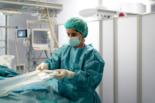 Female surgeon preparing instrument for operation in hospital
