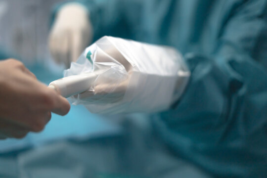 Healthcare professional using sterile ultrasound probe on patient finger