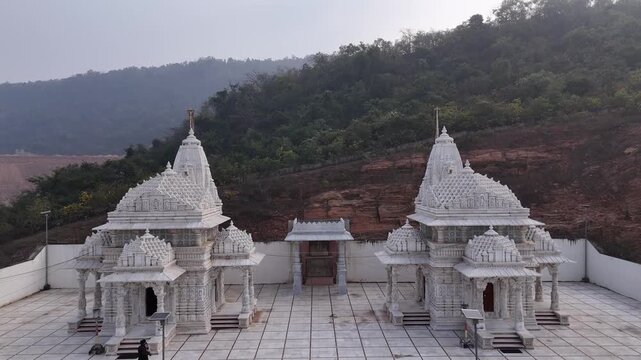 Aerial and ground shots of Lacchuar Jain Temple in Jamui, Bihar showcasing its ancient Jain architecture, serene hilltop setting and peaceful natural surroundings. Clear details, clean lines and herit
