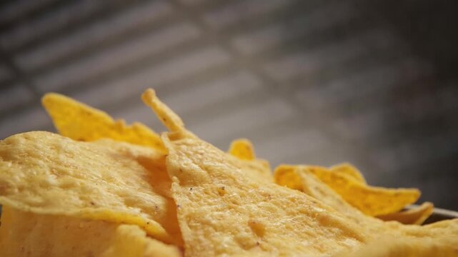 Corn chips, mexican nachos, slow motion footage of crispy yellow tortilla chips