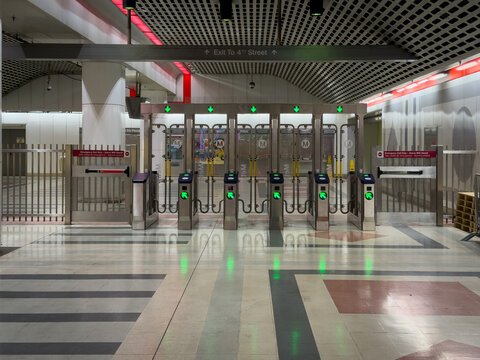 LOS ANGELES, CA, OCT 5, 2025: Interior Pershing Square LA Metro station fare gates with green approval lights, modern design, "Exit to 4th Street" sign, train visible on right
