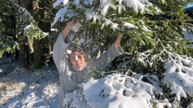 Woman having fun with first snow in the forest