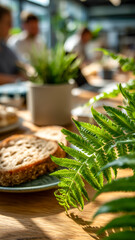 Sunlit brunch table with fresh bread and green fern. Cozy cafe atmosphere. A vibrant & healthy lifestyle in a modern setting.