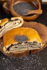 cut fresh wheat bun with lots of poppy seeds, soft bun with poppy seeds on the table