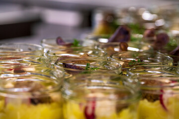 The salad inside the glass in preparation inside a kitchen