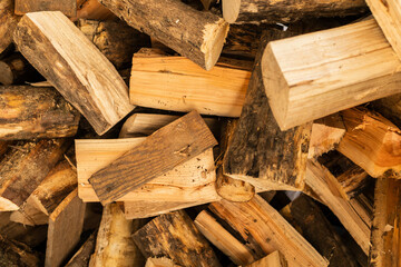 A pile of firewood logs is neatly arranged, showcasing various types and textures of wood. This collection is ideal for creating warmth during chilly days and nights