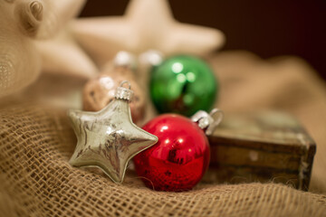 vintage christmas ornaments on burlap fabric with warm light creating an old fashioned tree decoration concept of holiday decor and retro home styling