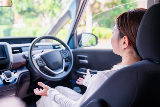 自動運転の車で手放し運転をする若い女性