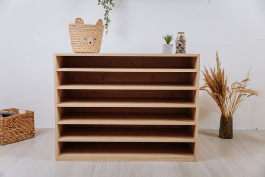 Wooden multi tier shelf cabinet in modern playroom interior, front view