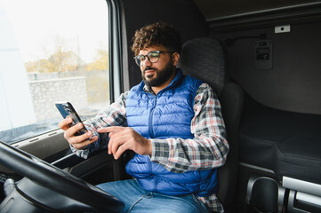 Truck driver using smartphone working inside cabin