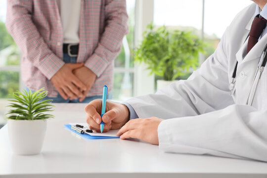Male doctor working with patient in clinic, closeup. Prostate cancer awareness concept - Powered by Adobe
