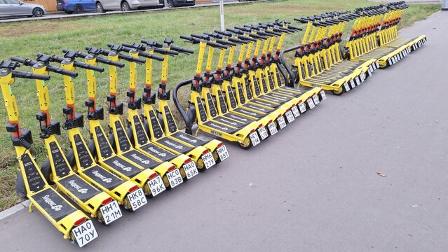 Russia, Moscow- 16 October 2025.Neatly organized row of yellow electric scooters parked outdoors for shared urban mobility