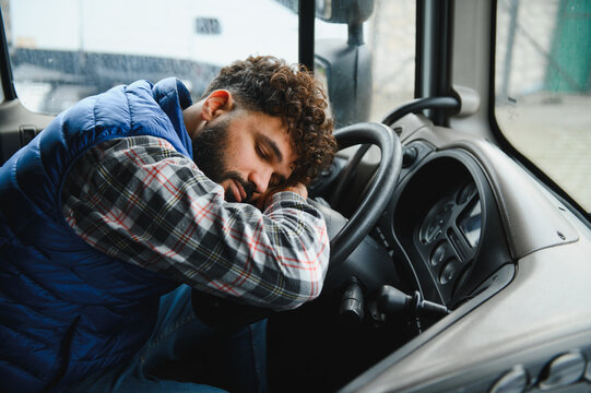 Tired truck driver sleeping on steering wheel