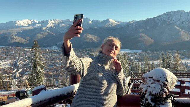 Woman making selfie on snowy town background