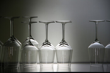 Upside down wine glasses on glass shelf