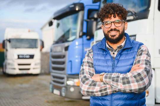 Happy male truck driver standing with arms crossed