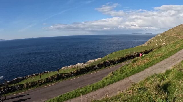 ocean view from the hill, cyclist biking in groups on slea head drive, dingle peninsula