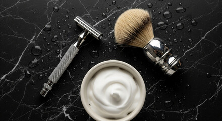 Overhead view of a classic wet shaving setup: a safety razor, a badger hair shaving brush, and a bowl of white shaving foam, all resting on a wet, black marble surface with water droplets