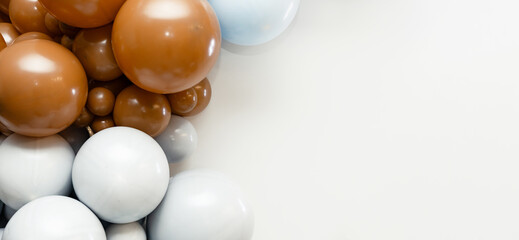 Warm brown, white and light blue balloons forming a decorative festive garland on a clean white background, ideal for party banners, invitations or celebration layouts.