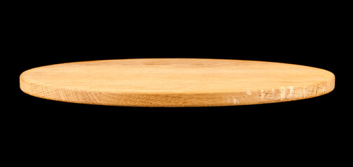 Round wooden board isolated on black background.