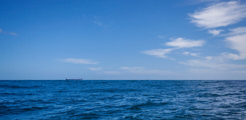Bulk carriers move across the ocean on a clear day.