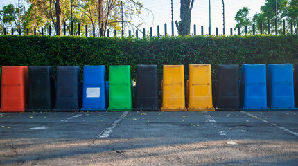 Garbage cans of different colors are turned upside down in row.
