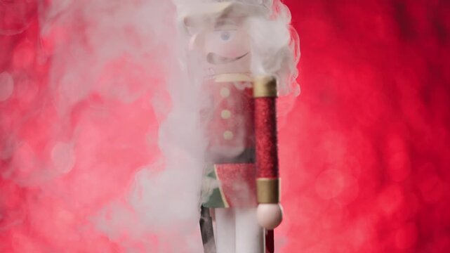The Toy Nutcracker covered in thick fog, twirls lively in front of a bright red bokeh background