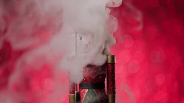 Portrait in front of a lively bokeh studio background, the Toy Nutcracker concludes with a tight head shot, covered in smoke.